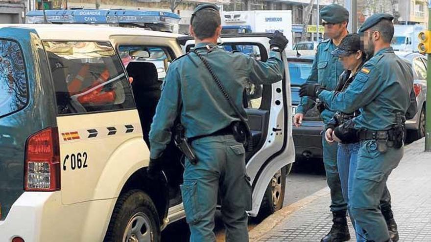 Guardias civiles trasladan a una detenida en la operación antidroga, tras un registro.