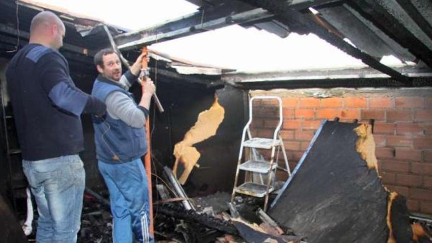 Dos albañiles, trabajando en una de las habitaciones quemadas por las llamas.  // J.L.Oubiña