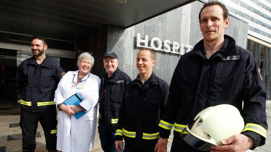 Los bomberos con la jefa de la planta de Oncología Infantil del HUCA esta mañana.