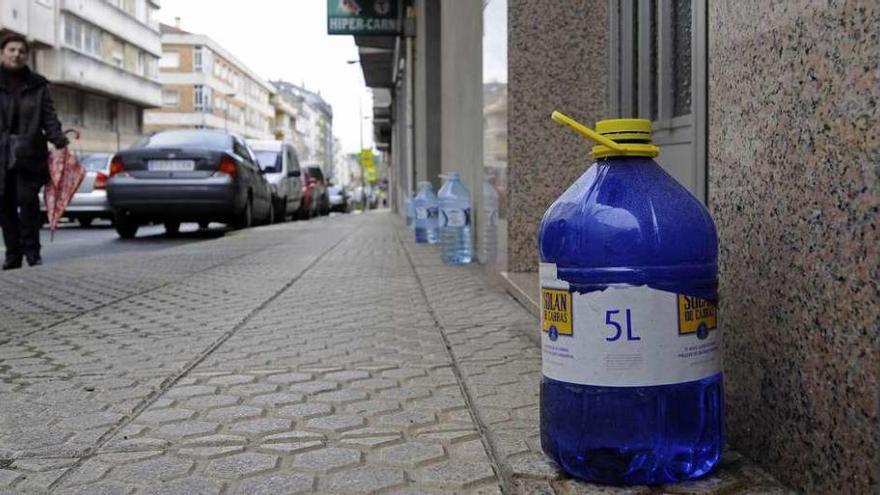 Las garrafas de agua, ayer, en la calle B de Lalín, alineadas sobre la acera. // Bernabé/Javier Lalín
