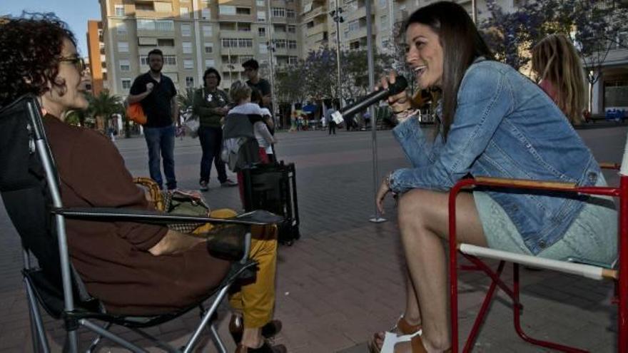 Una vecina atiende a las explicaciones de Mireia Mollà micrófono en mano.