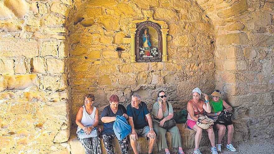 Visitantes descansando bajo la Virgen de los Esclavos.