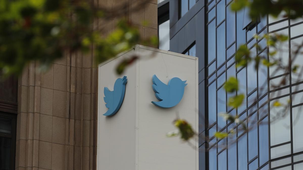 Workers remove letters from the iconic vertical Twitter sign after Elon Mus rebrands as X