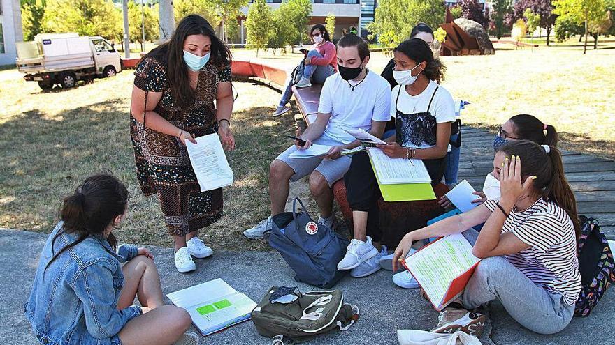 Alumnas estudiando a la sombra, en el césped del campus de Ourense.