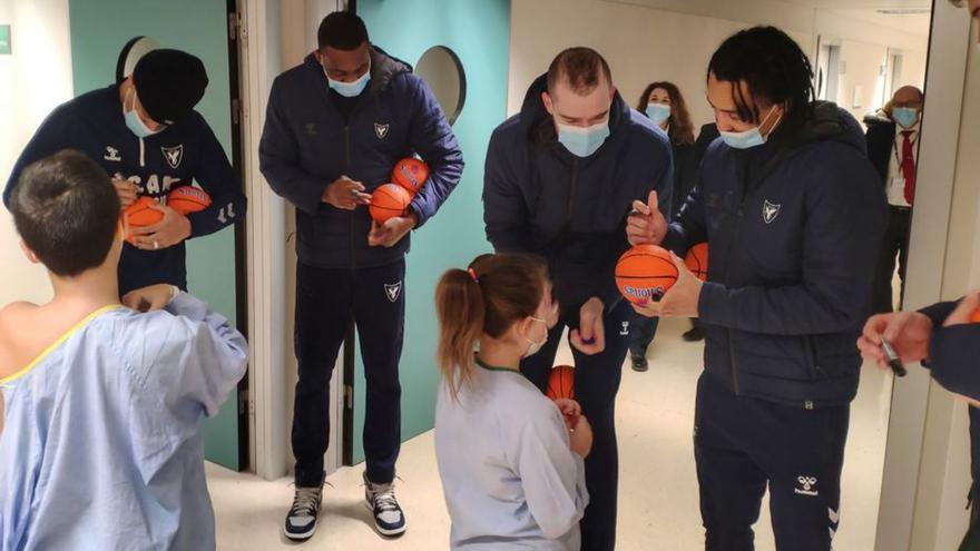 Los jugadores, firmando balones a los niños. | UCAM MURCIA CB