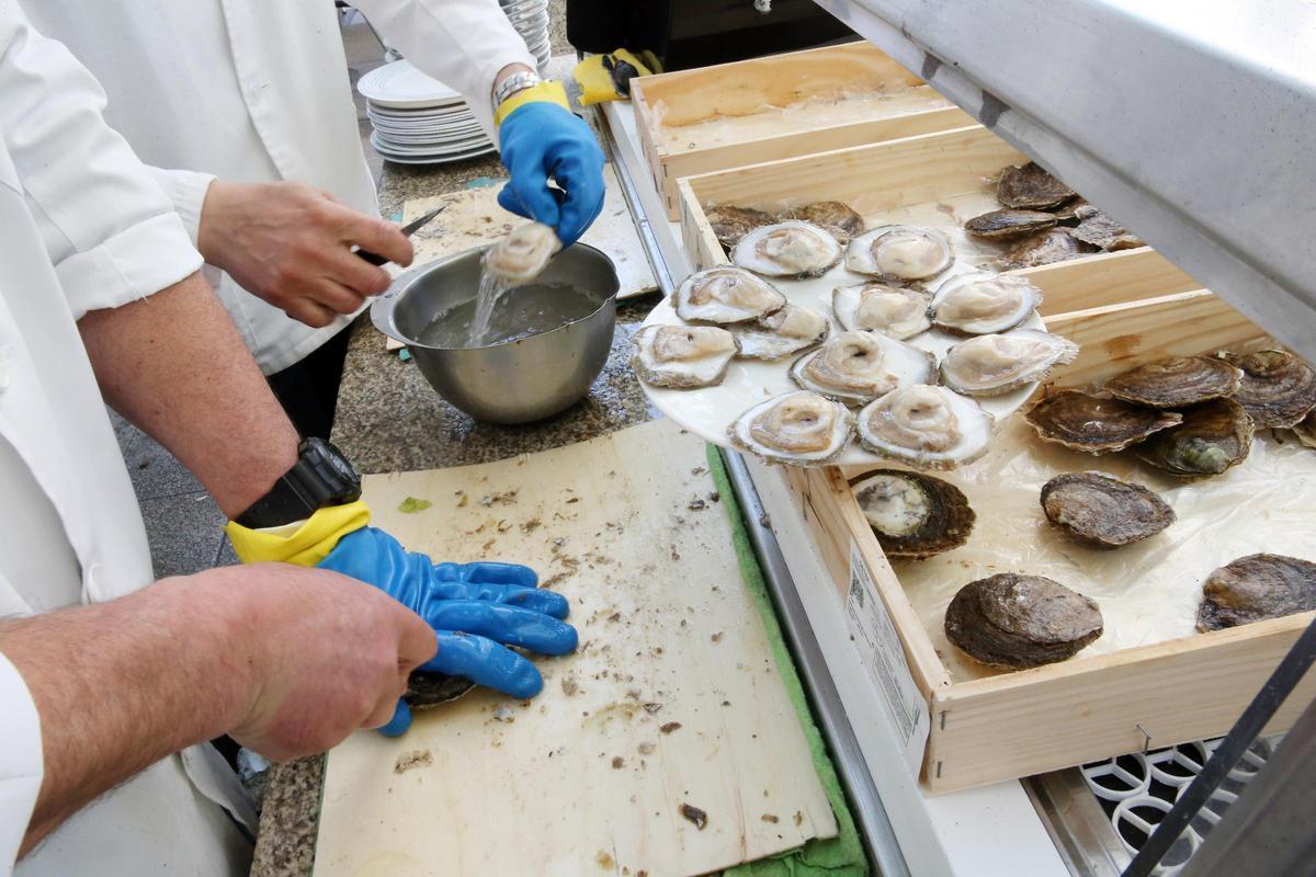 Dos personas preparan una partida de ostras.