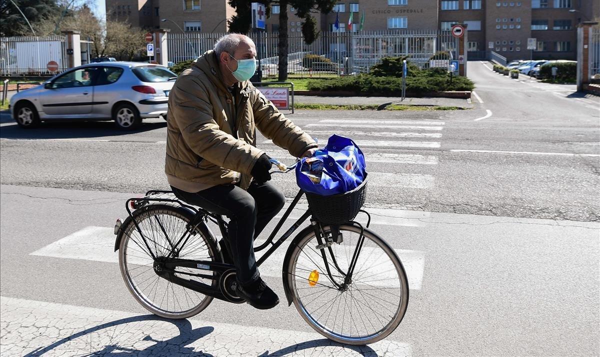 zentauroepp52734551 a man wearing a protective mask rides his bicycle past the h200317191645