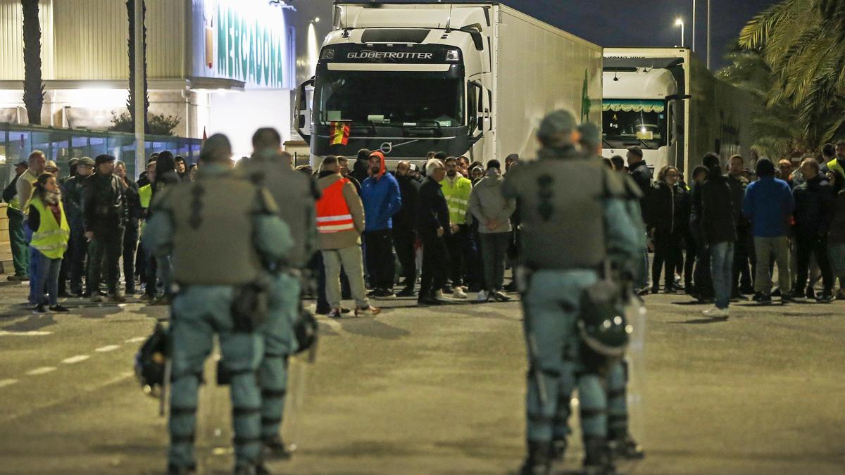 Los agricultores bloqueando el paso de camiones ante los antidisturbios de la Guardia Civil.