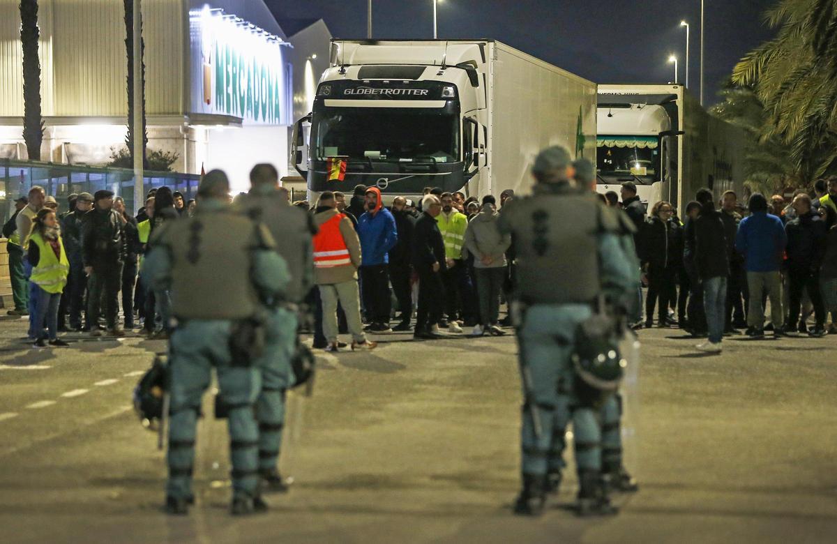 Los agricultores bloqueando el paso de camiones ante los antidisturbios de la Guardia Civil.