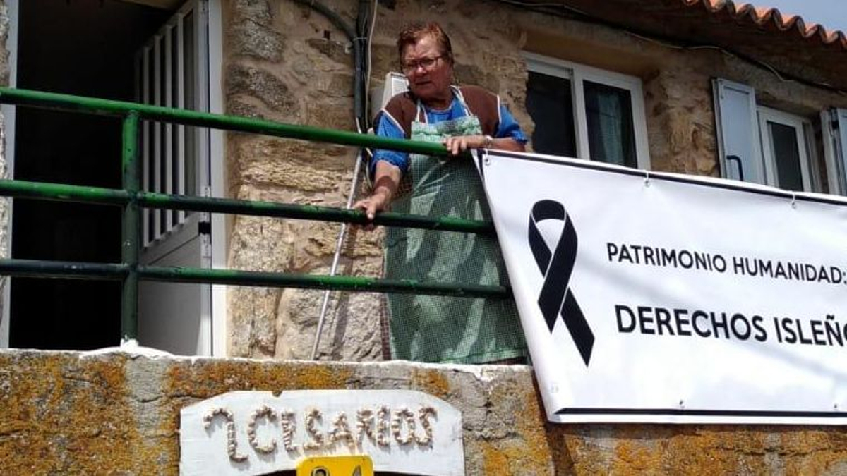 Victoria López en su casa de Ons con un cartel reivindicativo en el año 2019.