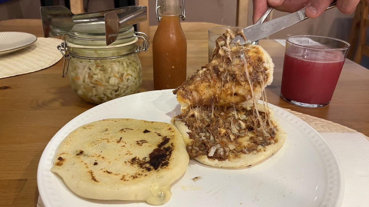 Una pupusa cerrada y una pupusa de carne y queso, abierta.