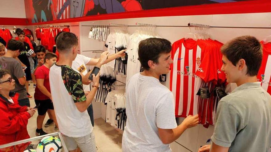 Sobre estas líneas, varios niños observan las camisetas del Sporting en la tienda de San Bernardo. A la derecha, María Fernández, tras adquirir su camiseta.