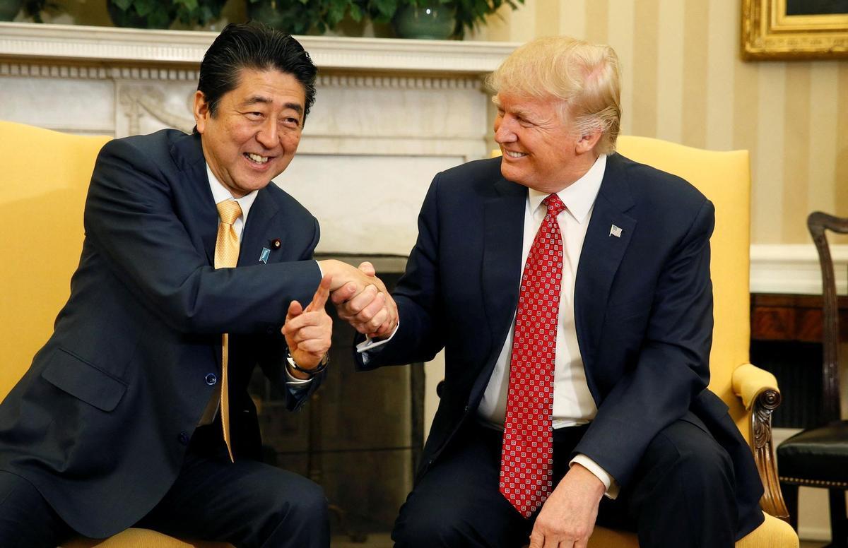 FILE PHOTO: Japanese Prime Minister Abe shakes hands with U.S. President Trump during their meeting in the Oval Office at the White House in Washington