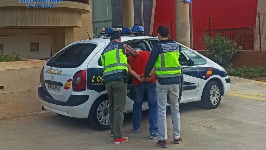 Dos policías custodian al detenido.