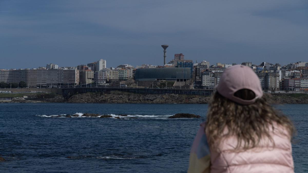 Una mujer observa el horizonte desde el paseo marítimo de A Coruña.
