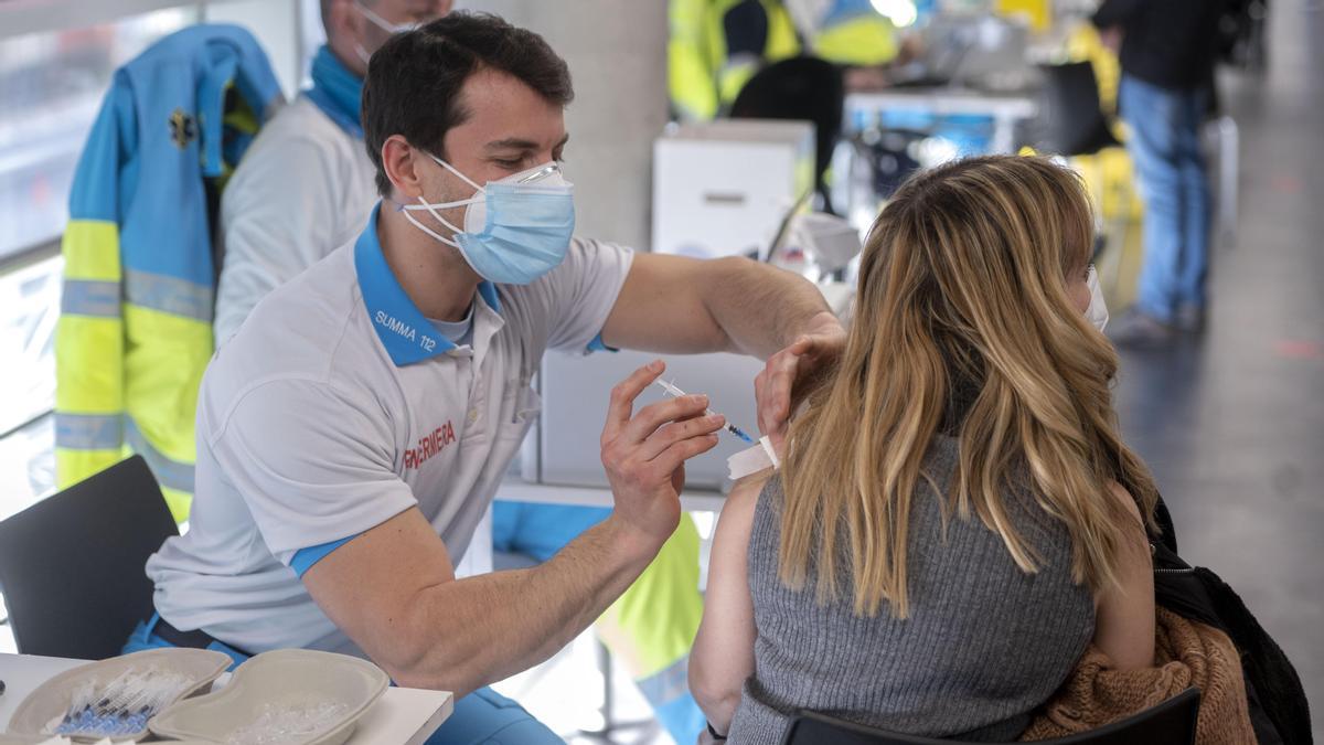 Un sanitario administra la vacuna del coronavirus a una mujer.