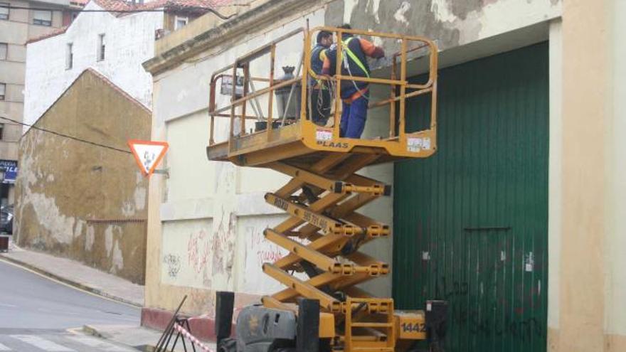 Operarios trabajando en la fachada del almacén de Albo.