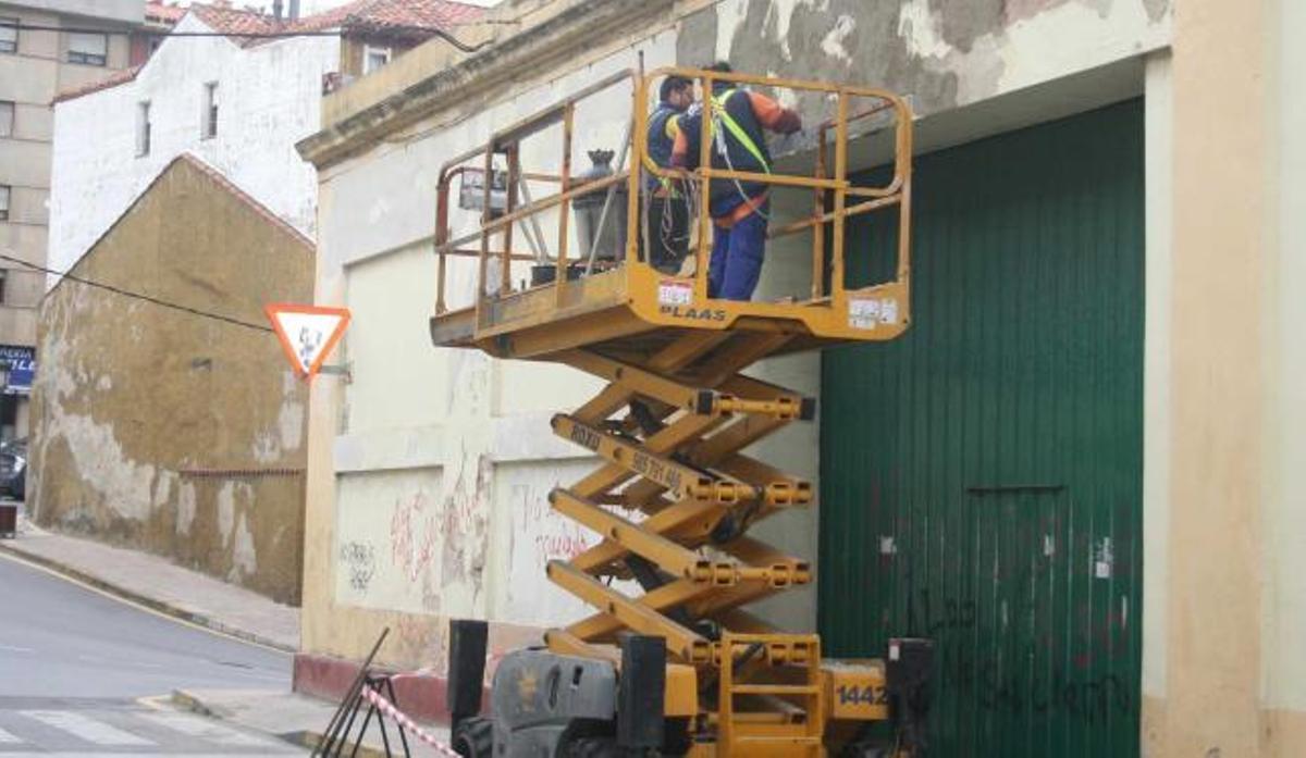 Operarios trabajando en la fachada del almacén de Albo.