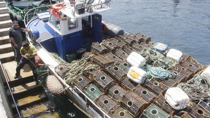 Dos marineros recogen las nasas tras el último día de captura de pulpo.