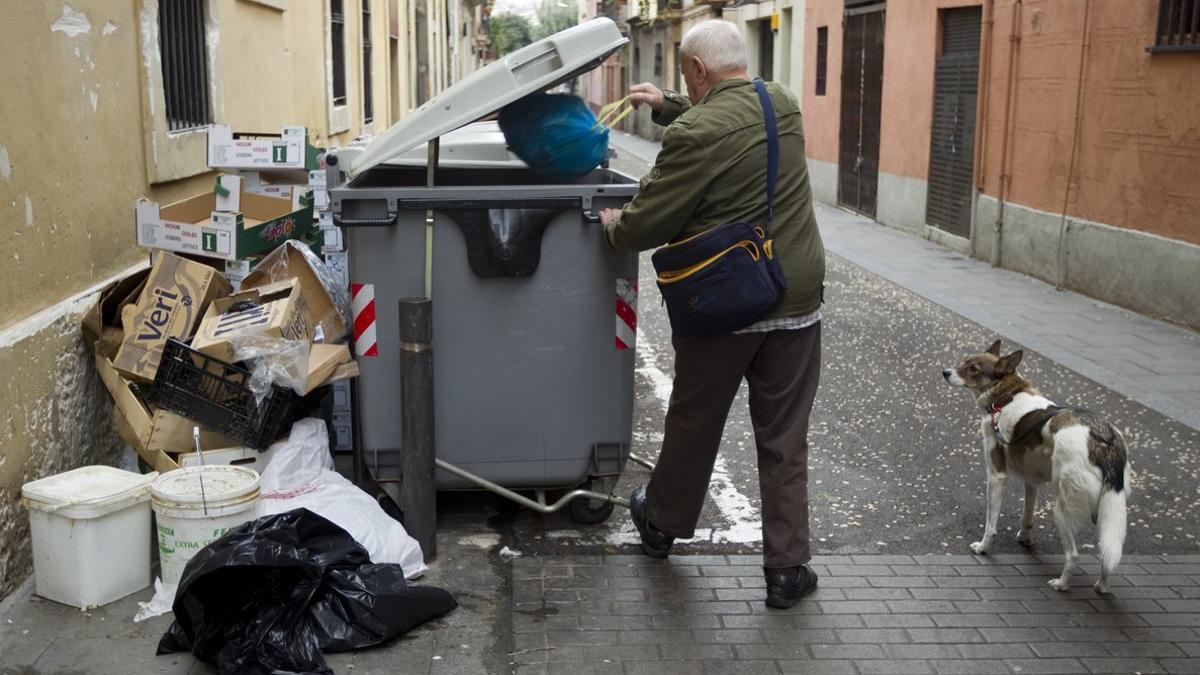 Un hombre tirando la basura al contenedor