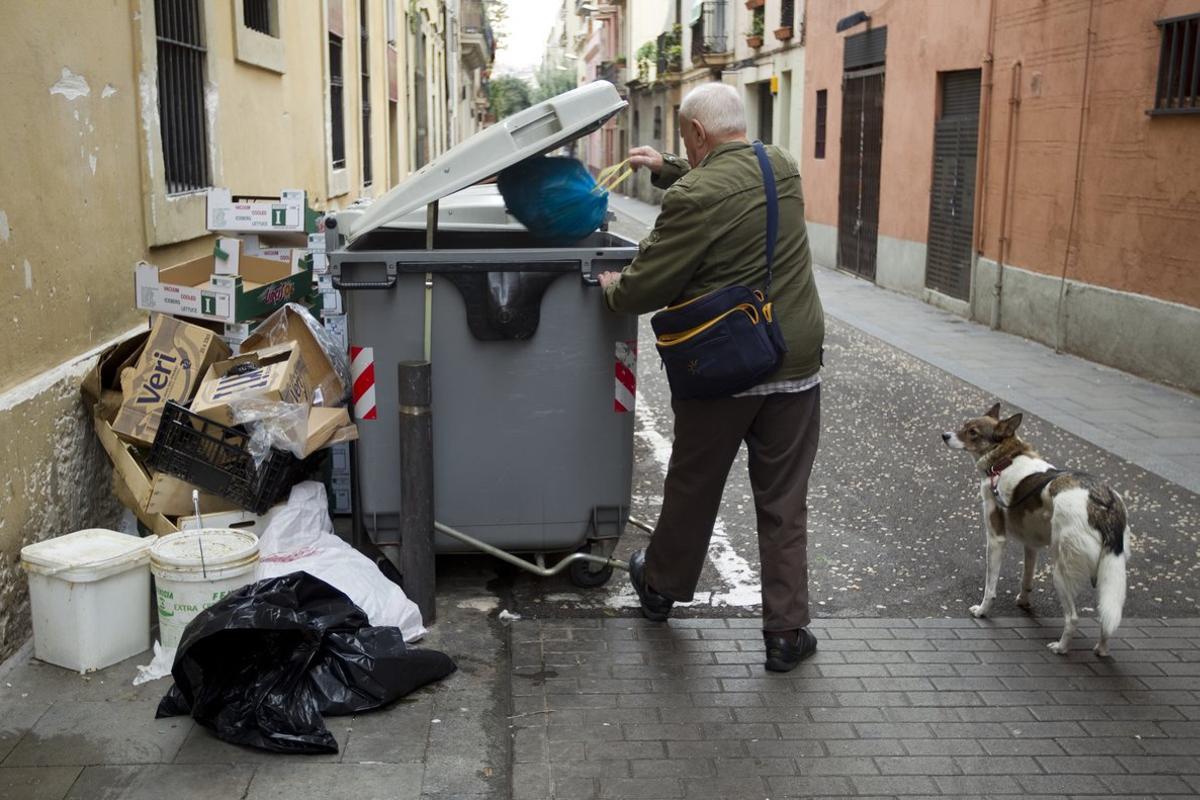 Un hombre tirando la basura al contenedor.