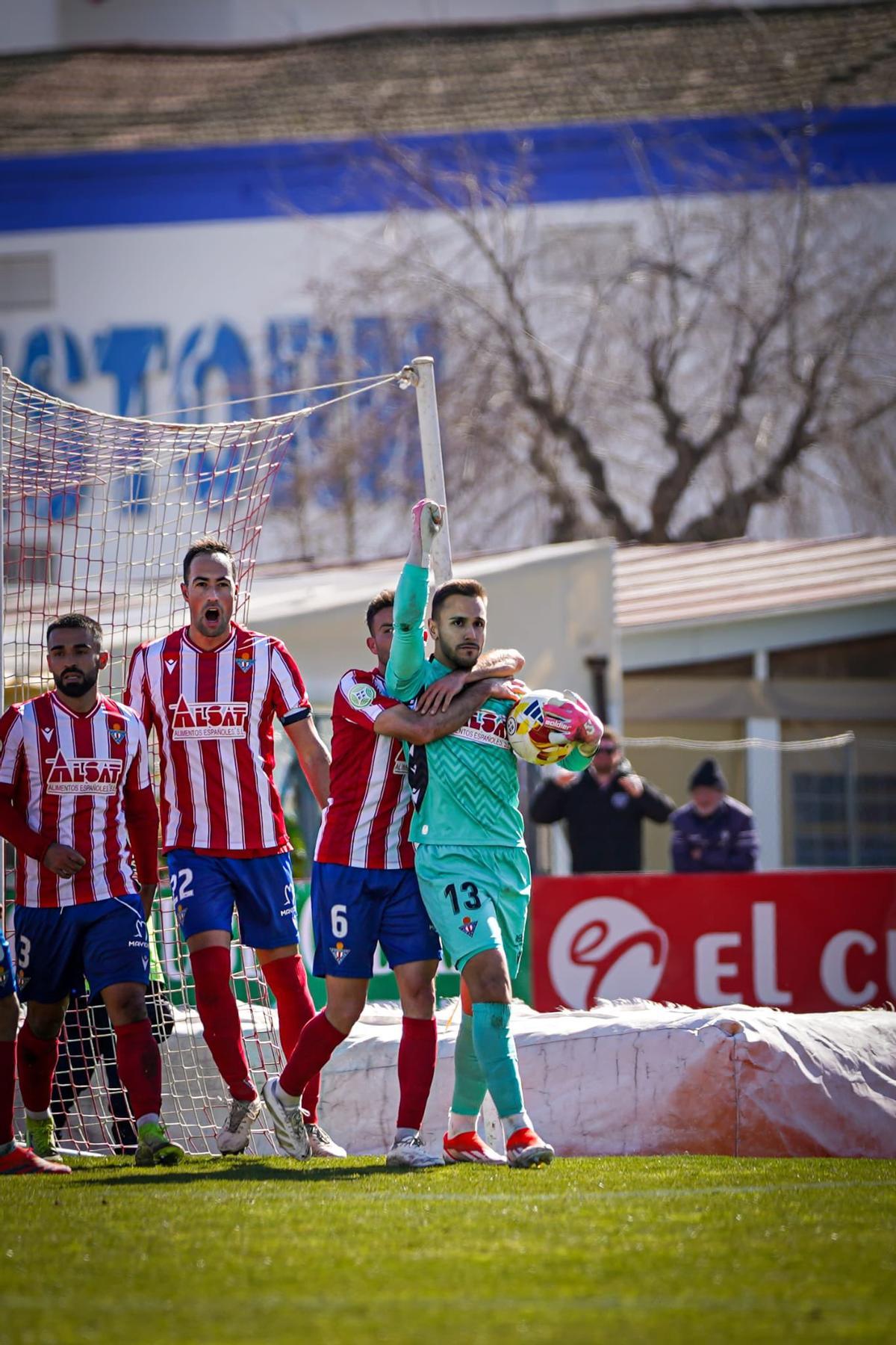 Jugadores del Don Benito felicitan a César Llera por atrapar un penalti.