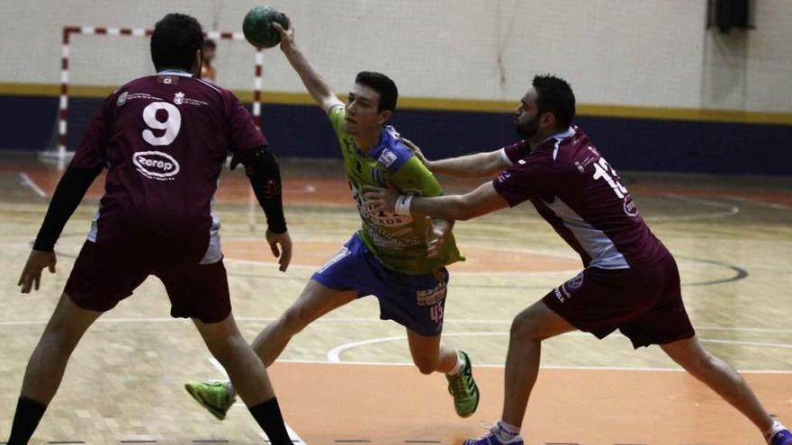 Raúl Maíde amaga frente a un defensor del Virgen del Camino siendo agarrado por otro.