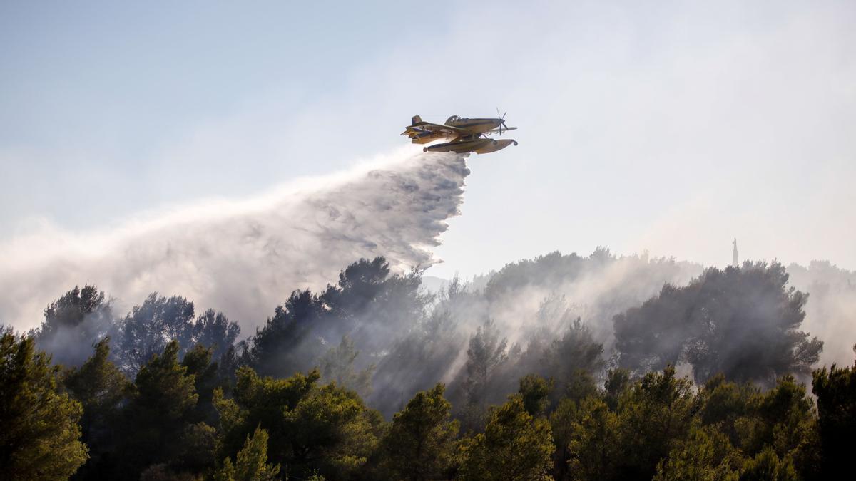 Una avioneta descarga agua sobre un incendio en Ibiza.