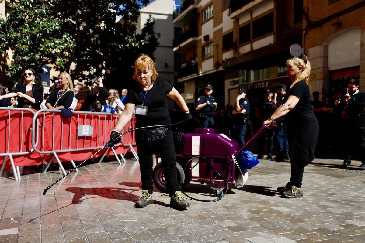 Dos empleadas echan líquido anticera este Jueves Santo de 2025 en la calle Compañía