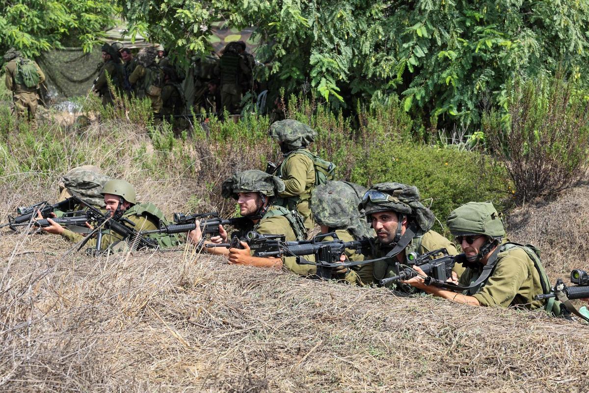 Soldados de Israel toman posiciones en Kfar Aza, al sur de Israel, en la frontera con la Franja de Gaza.
