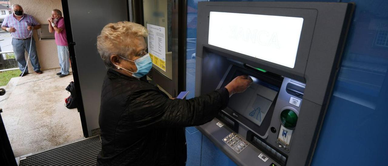 Una mujer mayor utilizando un cajero automático.
