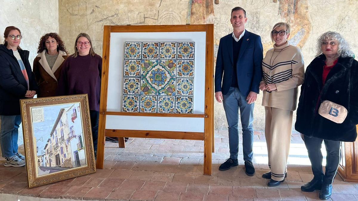 La alcaldesa de Càlig, Ernestina Borràs; el diputado de Cultura, Alejandro Clausell; y el equipo de restauradoras de la Diputación, junto al panel cerámico del Palacio de los Vallterra.