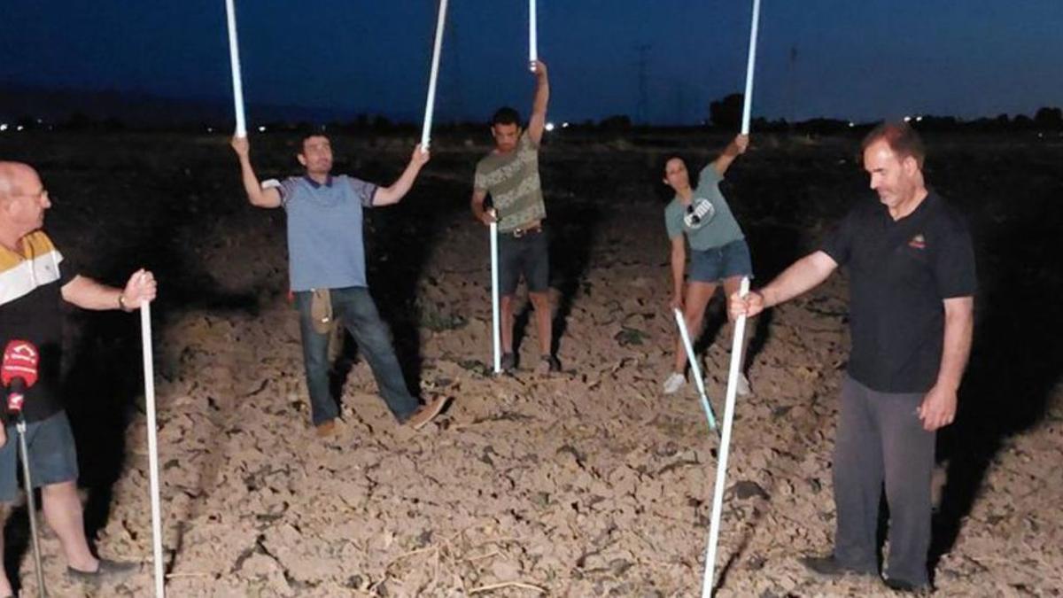 Los vecinos muestran los tubos fluorescentes en el campo.