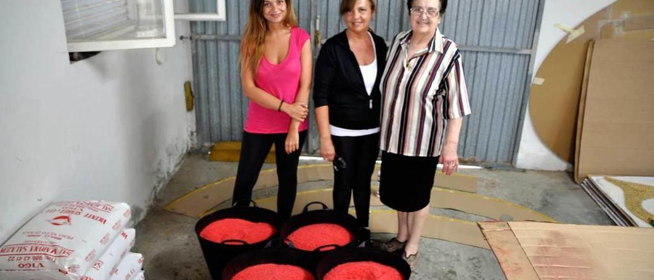 Bárbara Rodríguez, Begoña Pérez y Delta García, con la sal que utilizarán en las alfombras; a la derecha, Gonzalo González utilizando la &quot;cipresera&quot;.