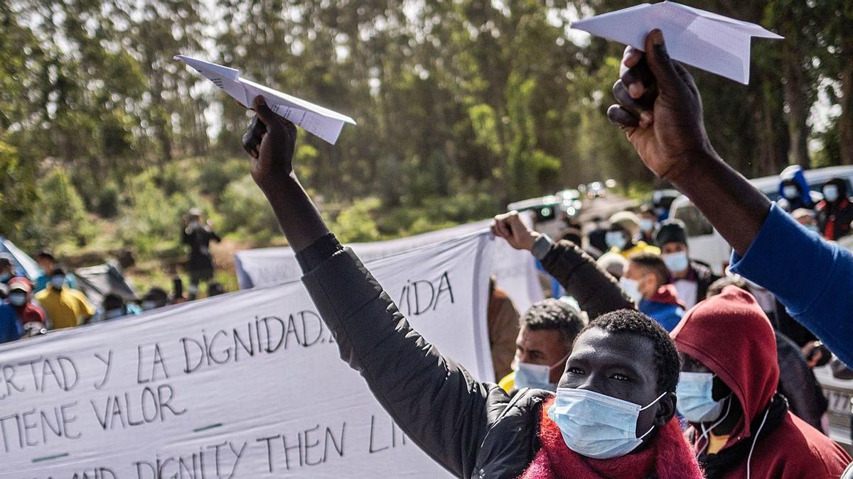 Imágenes de inmigrantes que se manifestaron el sábado en las puertas del campamento de La Raíces, en La Laguna, reclamando que se les deje continuar sus viajes hacia el continente. | | LP/DLP