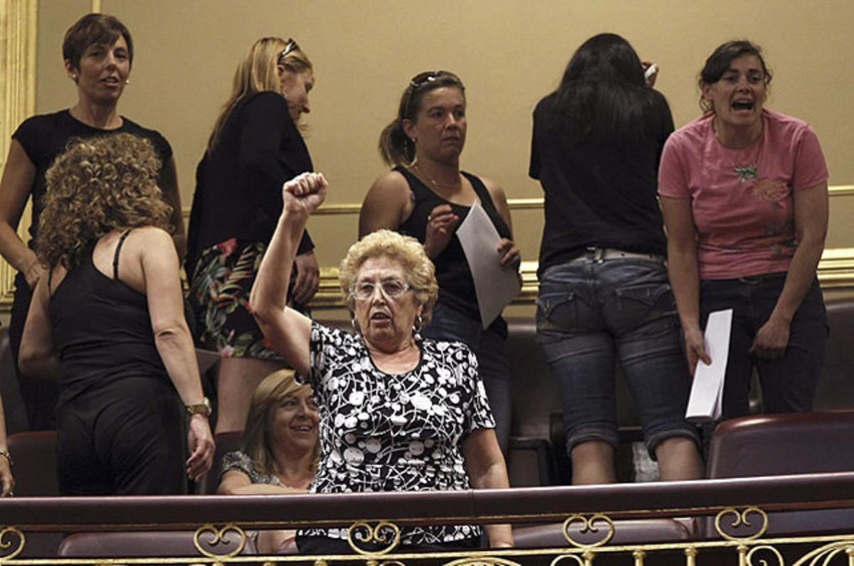 Un grup de dones i familiars de miners protesten a la tribuna de convidats del Congrés dels Diputats, durant el ple de control al Govern a la Cámara baixa.