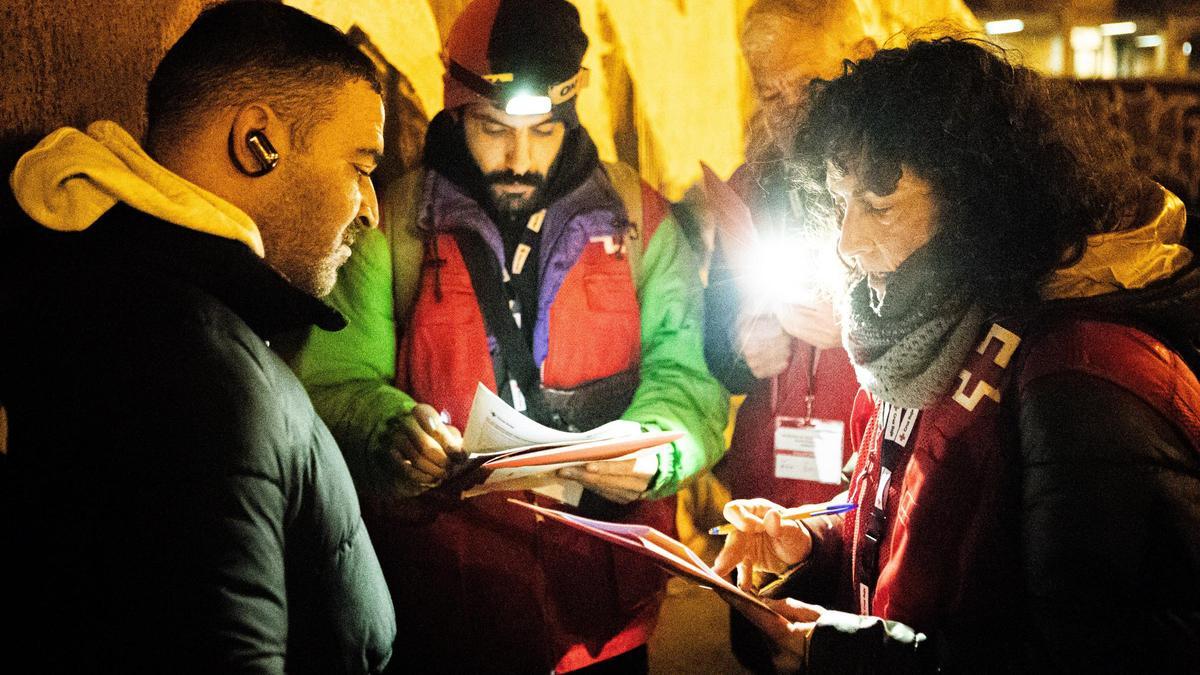 Dos voluntarios de Cruz Roja hablan con una persona sin hogar durante el recuento de este miércoles.