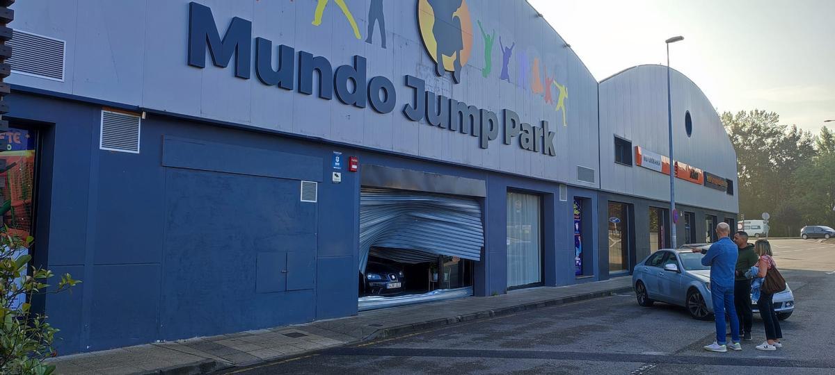 El coche empotrado contra la puerta del centro de ocio.
