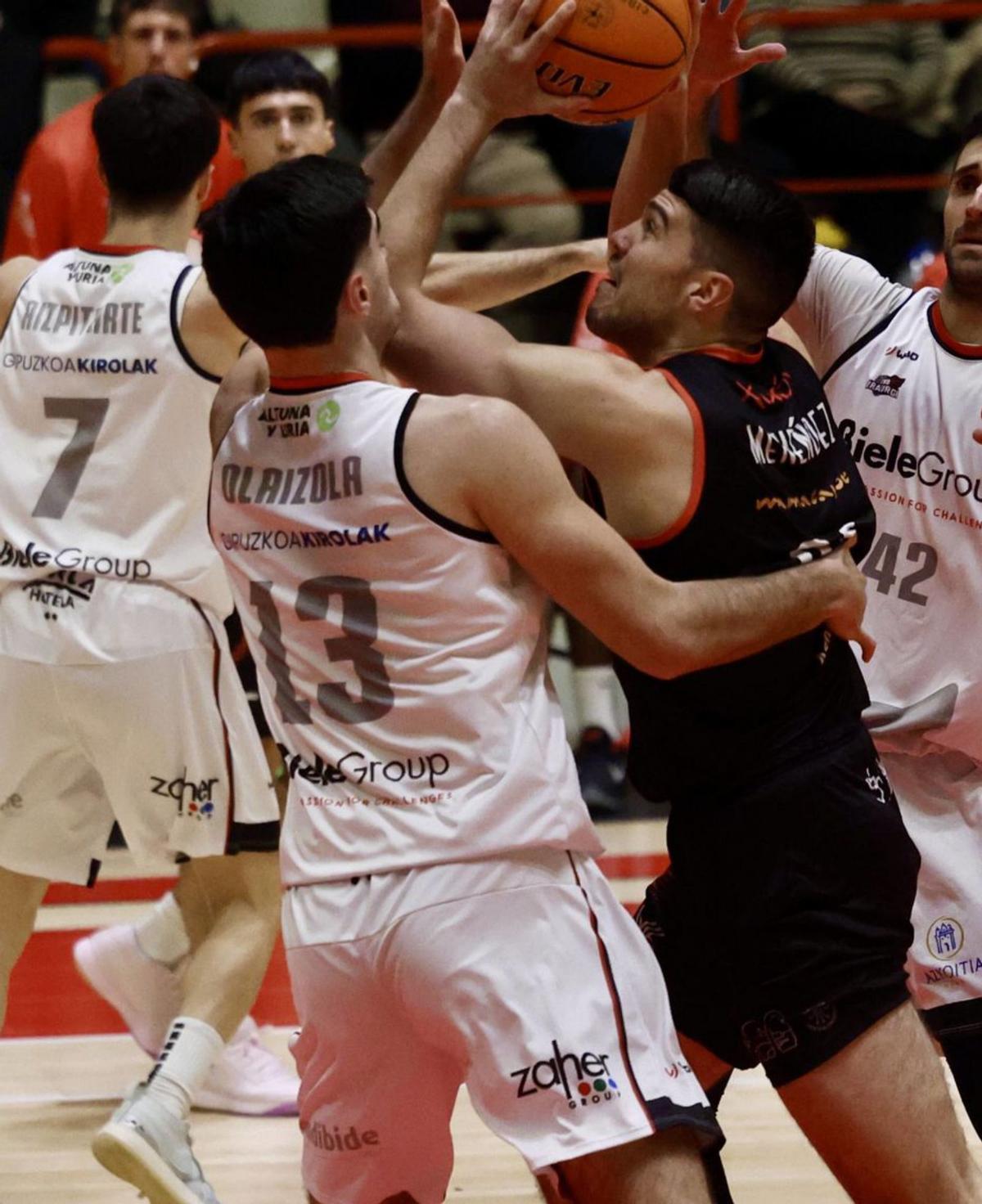 Javi Menéndez trata de anotar ante la defensa de Olaizola.  |