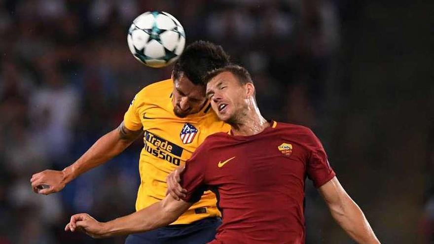 Dzeko y Savic pugnan por alto por un balón en el Olímpico. // Reuters