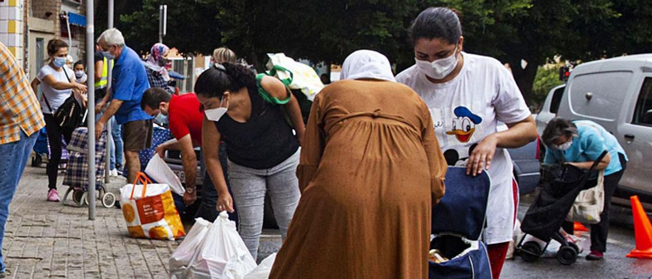 Personas recibiendo alimentos en Alicante.