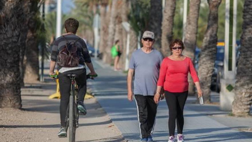 Un ciclista y dos peatones, por una zona céntrica de Elche.