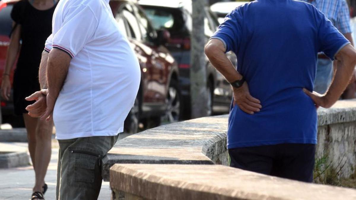 Dos hombres con exceso de peso en la calle.