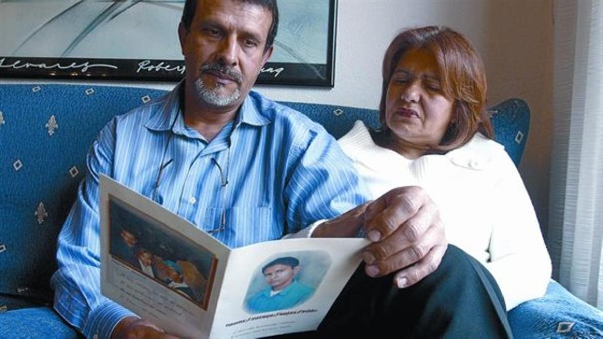 La primera víctima mortal 8 Los padres de Ronny Tapias hojean la tarjeta de recordatorio de su funeral, en el 2005.