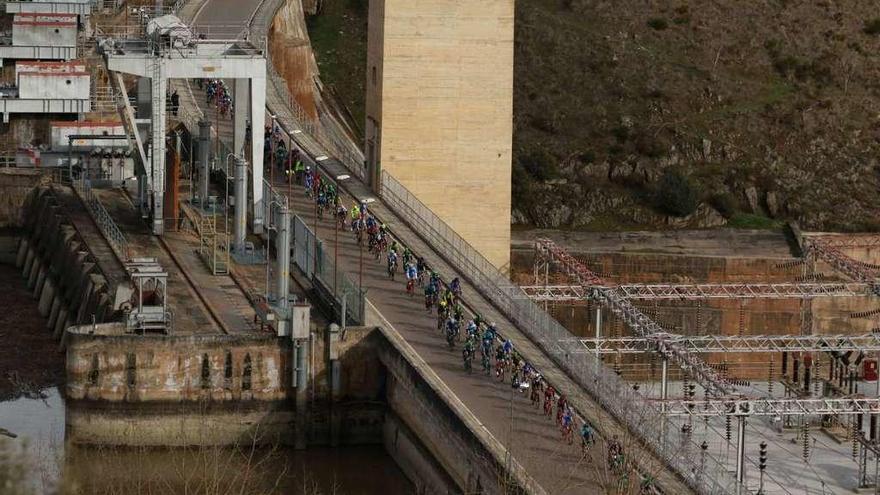 Un pelotón de ciclistas cruza la coronación de la presa y central hidroeléctrica de Villalcampo.