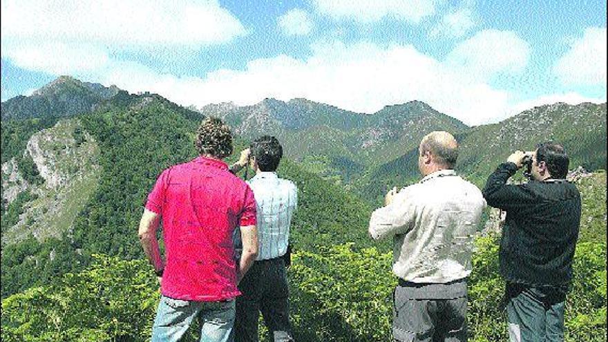 Un grupo de visitantes, acompañados por un guarda del parque de Redes, observa el paisaje desde el valle del río Monasterio.