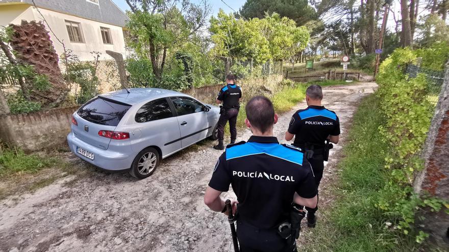 Agentes de la Policía Local de Cangas, supervisando vehículos aparcados en las proximidades de una playa de O Hío.