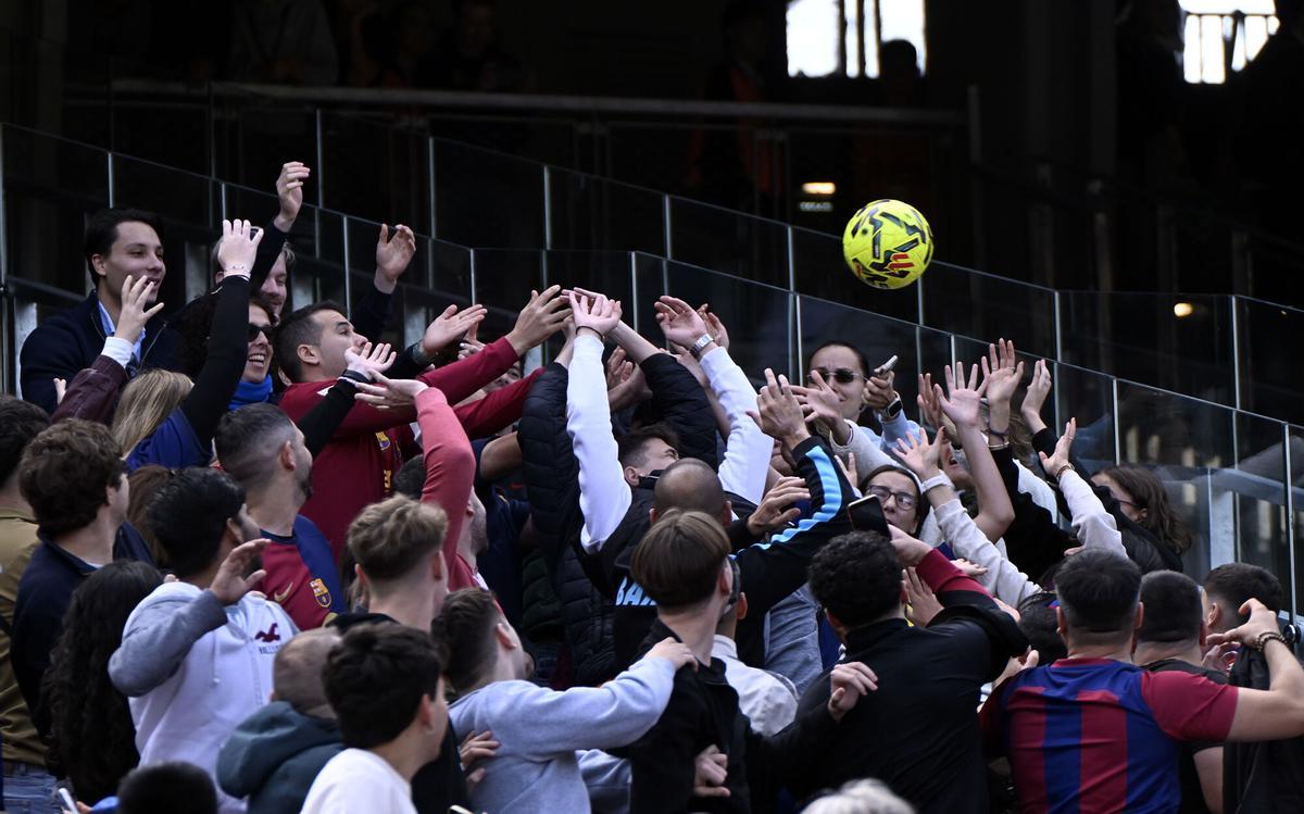 Barcelona. 07.11.2025.  Deportes.  Aficionados tratan de coger uno de los balones lanzados por los jugadores azulgrana durante el entrenamiento de los jugadores del Barça en el Spotify Camp Nou en el primer test con asistencia de público en el estadio. Fotografía de Jordi Cotrina