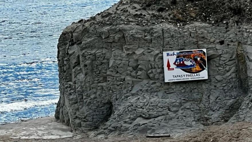 El cartel está clavado en el cortado de la playa de la Barraca