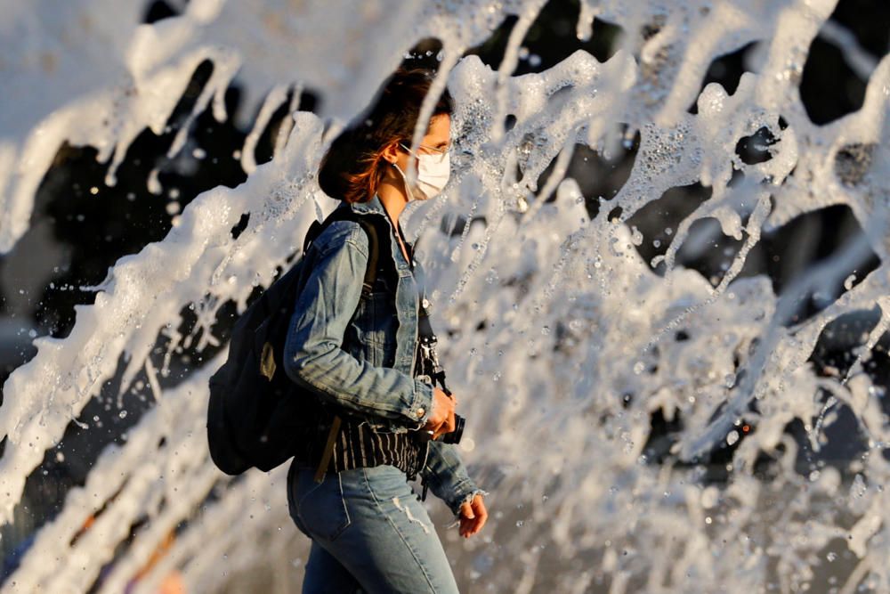 A woman wearing a face mask walks past a ...